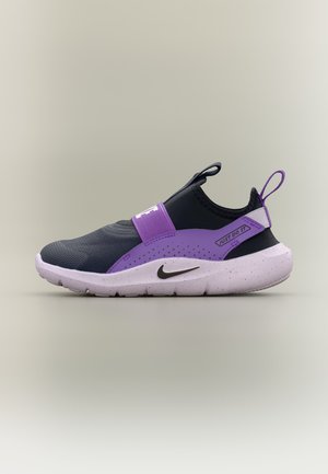 Černo-fialová nazouvací teniska Nike s bílou podrážkou s tečkami, černým logem Swoosh, páskem s nápisem „Just Do It“ a poutky na patě a jazyku.