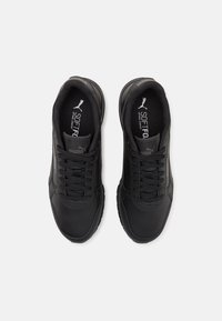 Scarpe da ginnastica nere con sopra in pelle sintetica, colletto imbottito e design con lacci. Presentano una suola testurizzata per aderenza e comfort.