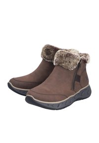 Bottes d'ankle marron avec un revers en fausse fourrure, en suède lisse, fermeture à glissière sur le côté, semelle en caoutchouc texturée et design à bout rond.