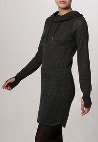 Robe en sweat à capuche de couleur gris foncé, en tissu doux, coupe ajustée avec des manches longues, dotée de fentes sur les côtés et de trous pour les pouces.