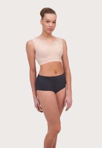 Lichtroze draadloze bralette met een V-hals en kantafwerking, met een gladde textuur, gecombineerd met hooggelegde donkerblauwe onderbroek, met een strak ontwerp.