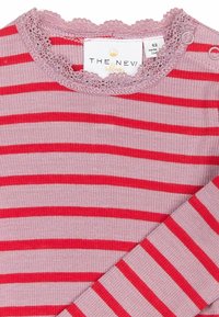 Maglione a maniche lunghe a righe con linee orizzontali rosa e rosse, texture a coste e scollatura rifinita in pizzo con due dettagli a bottone.