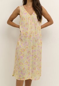 Kwiatowa sukienka bez rękawów w kolorze żółtym z różowymi i pomarańczowymi kwiatami, dekolt w kształcie litery V, miękka tekstura, o długości midi i luźnym kroju.