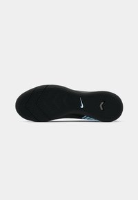 Zwarte sport schoenzool met gestructureerde patronen, blauwe accenten en een wit Nike-logo. Kenmerkt zich door een multidirectioneel loopvlakontwerp voor grip.