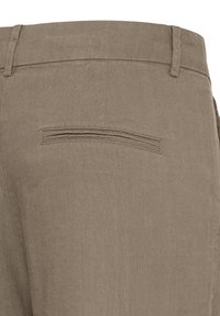 Vue arrière d'un pantalon marron montrant la taille avec passants pour ceinture et détail d'une poche arrière passepoilée simple.