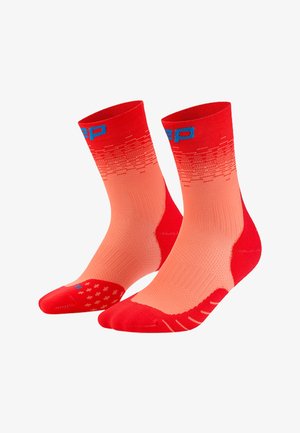Paar rot-orangefarbener Sportsocken bis zur Mitte der Wade mit blauer Schrift near oben und strukturierten Griffmustern an Sohlen und Zehen.