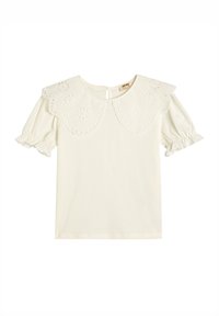 Blusa blanca de manga corta con escote redondo y cuello de ojo de perdiz bordado. Mangas con volantes, tela suave y cierre con botón en la parte posterior.