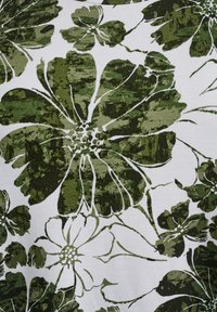 Žalias gėlių raštas ant balto audinio, su didelėmis tekstūruotomis gėlėmis, turinčiomis sudėtingas kontūras ir įvairias atspalvius žaliai ir baltai.