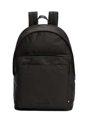 Black nylon backpack with rounded top, padded straps, front zip pocket, and embossed logo at the bottom. Smooth texture with minimalist design.