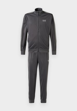 Gray tracksuit made of smooth fabric, featuring a zip-up jacket with a high collar, striped accents on sleeves, and matching tapered pants.
