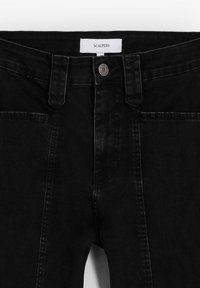 Svarta denimjeans med en jämn textur, med framknäppning och fickor, märkt med "SCALPERS." Klassisk rak passform.