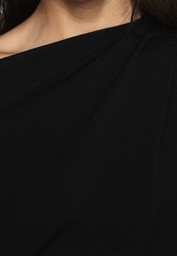 Czarna, żebrowana tkanina z diagonalnym wzorem. Gładka struktura i miękki spad, podkre�ślający dopasowaną sylwetkę odzieży.