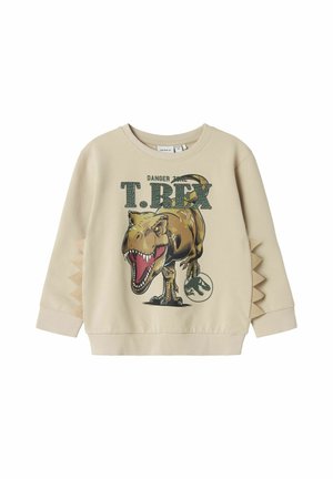 Sweatshirt beige con grafica di un T-Rex. Collo rotondo a coste, dettagli testurizzati sui lati che richiamano le spine dei dinosauri e stampa dettagliata.