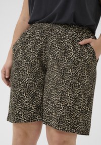 Šortsice s uzorkom leopard su napravljene od lagane tkanine, imaju elastičnu traku u struku i bočne džepove. Karakteriše ih crna i bež boja.