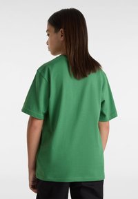 Grünes Baumwoll-T-Shirt mit lässiger Passform, Rundhalsausschnitt und kurzen Ärmeln. Schlichte Gestaltung ohne Muster oder Akzente. Rückansicht dargestellt.