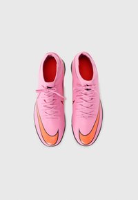 Scarpe da ginnastica rosa con una texture liscia, caratterizzate da un prominente logo Nike in nero e arancione, e una fodera interna rossa. I lacci sono standard.