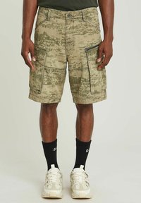 Camo cargo shorts in beige en groen, met meerdere zakken, een textuurstof en een met rits sluitend zijvak voor extra functionaliteit.