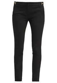 Pantalons noirs ajustés, avec une texture lisse, des poches latérales et des accents en métal doré sur la ceinture.