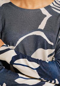 Pullover mit einem navy- und weißen abstrakten Muster, aus einem strukturierten Strickstoff, mit langen Ärmeln und einem weiten Ausschnitt.
