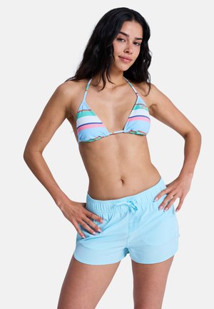 Lys blå bikini med trekantede kopper som har pastellfargede horisontale striper. Kombinert med matchende lys blå badeshorts med elastisk midje.