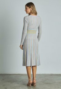 Langarmkleid mit vertikalen, mehrfarbigen Streifen, tailliertem Oberteil und ausgestellt Saum. Weicher Stoff mit elastischem Taillenbund.