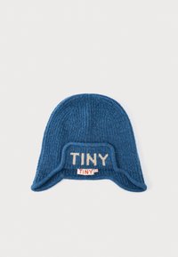 Blauer Strick-Mütze mit gerippter Textur, featuring ein beiges "TINY"-Logo auf der Vorderseite und einem kleinen roten Etikett an der Seite.