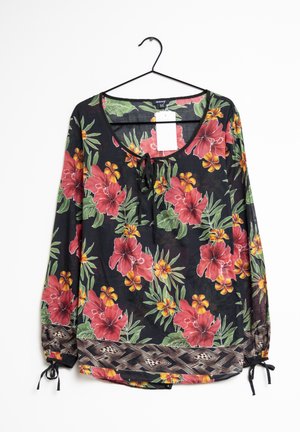 Blumenbluse mit langen Ärmeln, schwarzer Hintergrund, große rote und gelbe Blumen, geraffte Manschetten mit Muster und Schleifendetail am Ausschnitt.
