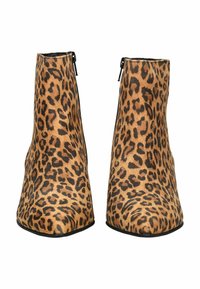 Une paire de bottines hauteur cheville avec un motif léopard et des fermetures éclair noires sur les côtés, présentées de face sur un fond blanc.