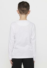 Witte langemouwen shirt met een rechte snit en ronde halslijn, gemaakt van lichtgewicht katoenstof, met een gladde textuur.