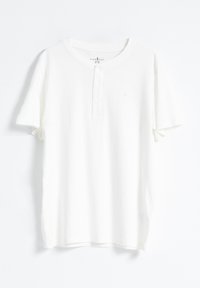 Camiseta blanca de manga corta hecha de tela suave. Presenta un escote estilo henley con tres botones y un logo sutil en el pecho.