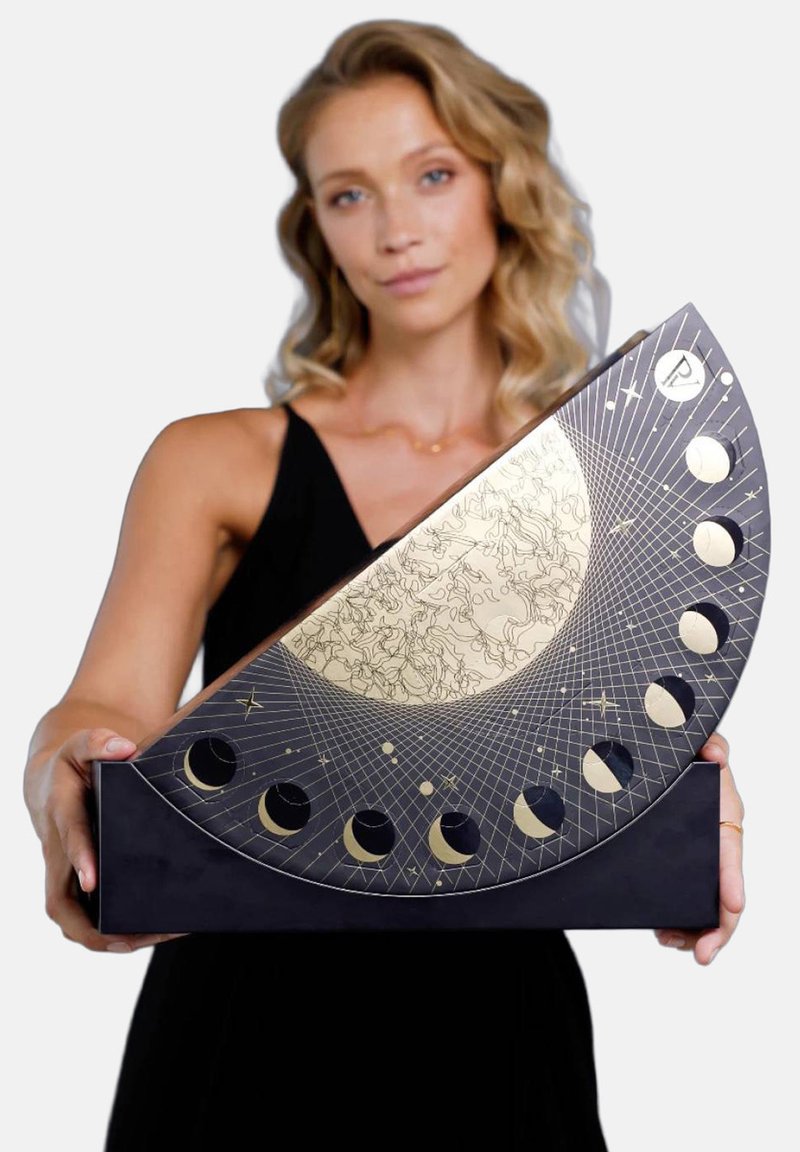 Black triangular display with gold moon phases and intricate designs; held by a person, featuring a smooth texture and geometric patterns.