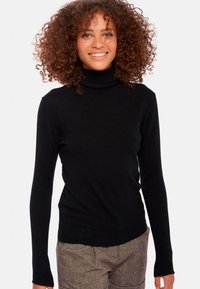 Schwarzer Rollkragenpullover mit langen Ärmeln, aus einem weichen Strickstoff gefertigt. Verfügt über ein tailliertes Design und einen gerippten Kragen.