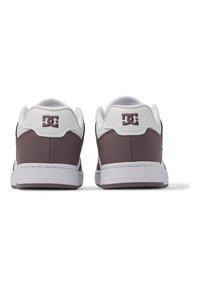 Brown and white low-top sneakers with a textured leather upper, white soles, and a logo accent on the heel.