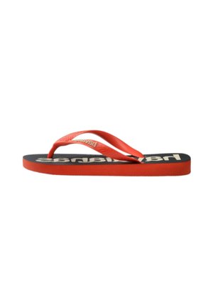 Chanclas de goma rojas con una correa texturizada y suela negra que presenta un logo en letras en negrita color beige. Diseño plano y sencillo para usocasual.