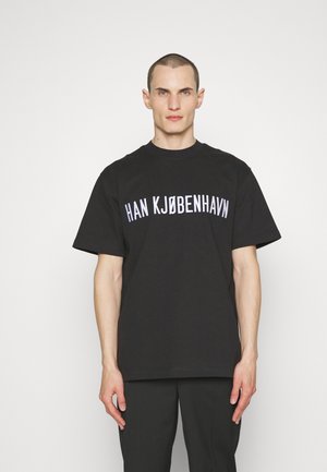 Black cotton t-shirt with a relaxed fit, featuring white text "HAN KJØBENHAVN" in bold, curved font across the chest.