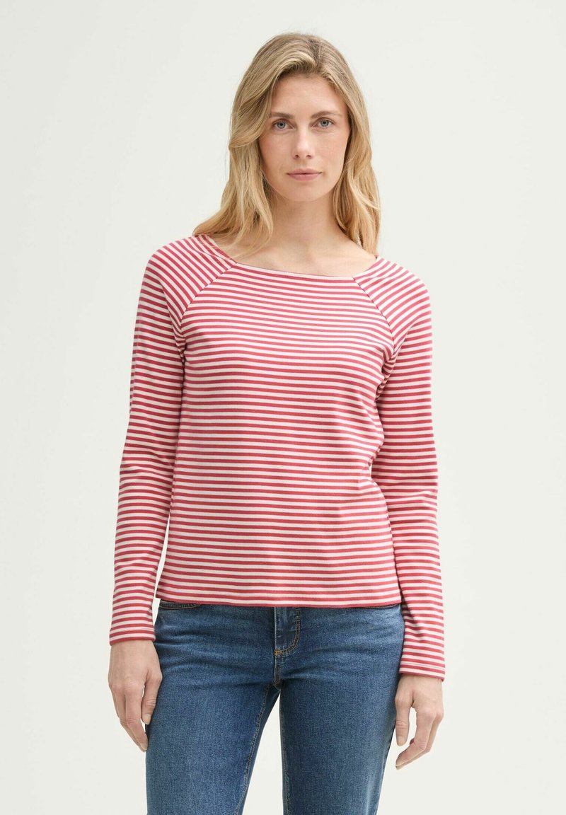 Langarm gestreept shirt in rood en wit, geribbelde textuur, vierkante halslijn en raglanmouwen, gecombineerd met blauwe denim jeans.