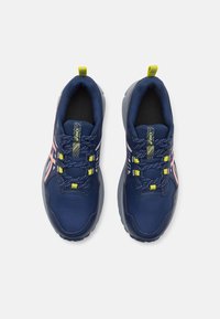 Zapatillas deportivas azul marino con parte superior de malla, acentos en rosa y detalles reflectantes. Presenta cordones amarillos brillantes y una suela texturizada.