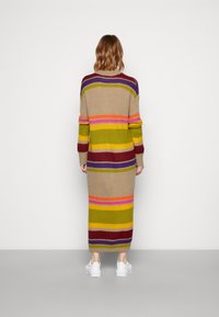 Stickad klänning med långa ärmar, flerfärgade horisontella ränder i grön, vinröd, rosa och gul; längd till mitten av vaden och avslappnad passform.