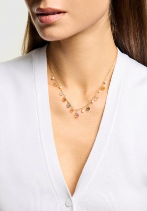 Collar de oro con múltiples piedras preciosas en forma de lágrima en tonos melocotón, rosa e iridiscente, con pequeños detalles de perlas.