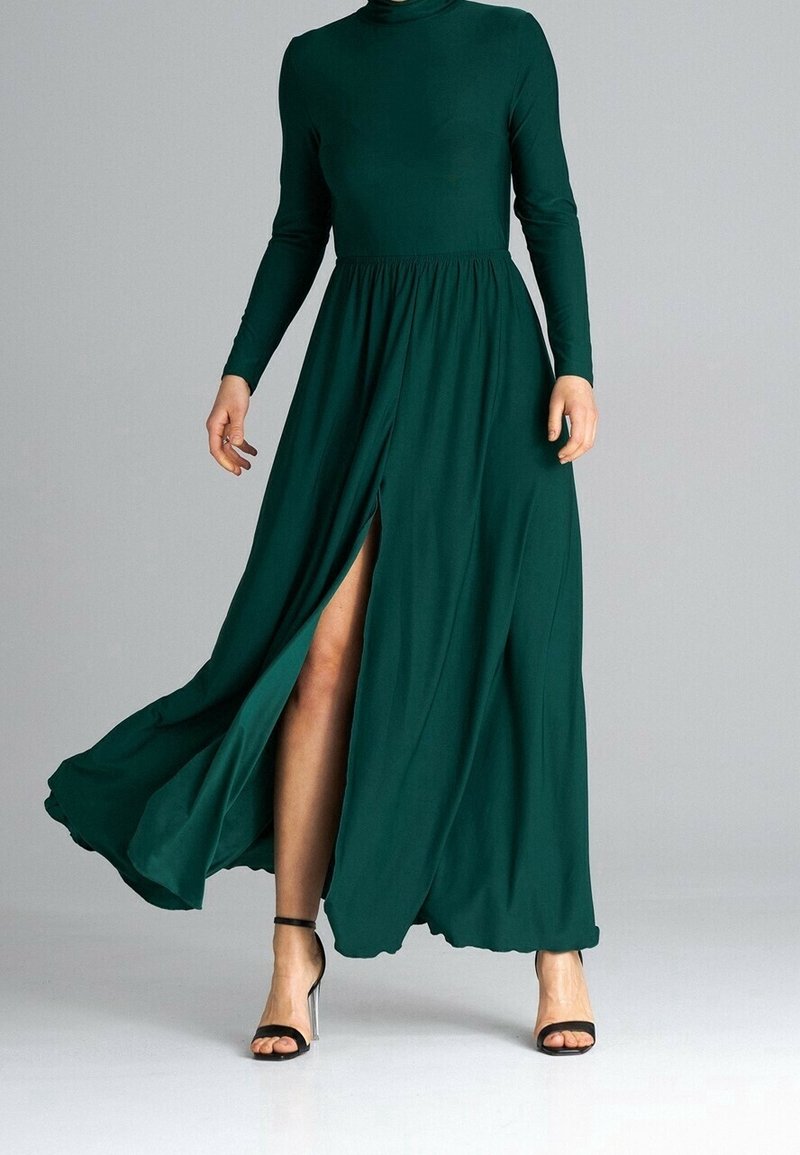 Langärmliges, tiefgrünes Kleid mit hochgeschlossenem Ausschnitt, elastischem Taillenbund und einem Oberschenkel hohen Schlitz; hergestellt aus einem weichen, fließenden Stoff.