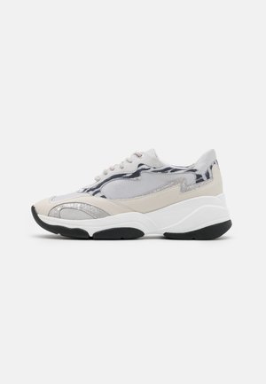 Hvid og beige sneaker med sort sål, mesh og læderpaneler, snørelukning og abstrakte grå og sorte mønstre på siden.