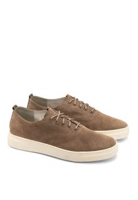 Braune Wildleder-Sneaker mit einer weißen Gummisohle, runder Zehenform und Schnürverschluss. Verfügt über dezente Nähte und einen kleinen Akzent auf der Zunge.