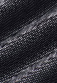 Czarna, teksturowana tkanina z wyraźnym diagonalnym splotem, w którym wyróżniają się uniesione nitki, poprawiające jakość dotykową i trwałość.