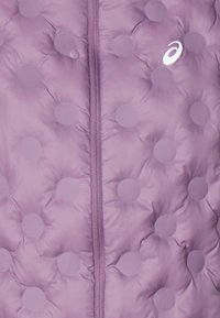 Leichte lila gepolsterte Jacke mit auffälligen runden Mustern, einem zentralen Reißverschluss und einem weißen Logo auf der linken Seite. Weiche Textur überall.