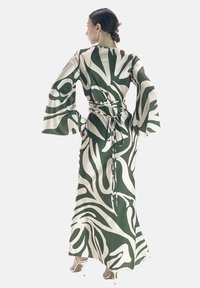 Robe longue vert et crème à motifs avec des manches évasées et une taille à nouer. Tissu lisse avec des motifs abstraits et fluides.