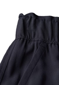 Dark navy trousers featuring an elastic waistband and smooth fabric texture. A clean finish with discreet stitching details.