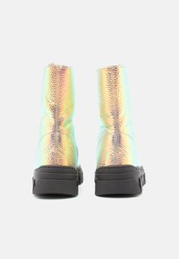 Bottes montantes en matériau irisé avec une surface texturée, semelle en caoutchouc noir et doublure intérieure moelleuse.