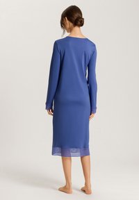Camicione a maniche lunghe in tessuto blu uniforme. Presenta una trama liscia, scollatura a girocollo e orlo trasparente con strisce orizzontali.
