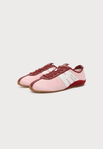 Paire de baskets roses et bordeaux à lacets avec des bandes blanches sur les côtés, des semelles marron et l’inscription « Marc Jacobs » sur le côté.