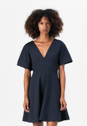 Vestido azul marino con un escote en V profundo, mangas cortas y anchas, y un corpiño ajustado que se ensancha en una falda de vuelo. Textura suave, diseño minimalista.